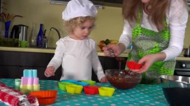 Mutfak masasında kek yapmasına yardım ederken eğlenen bir kız. 4K