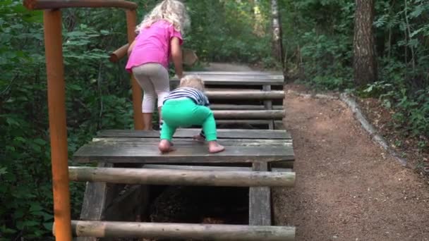 Діти ходять через дерев'яний палички міст — стокове відео