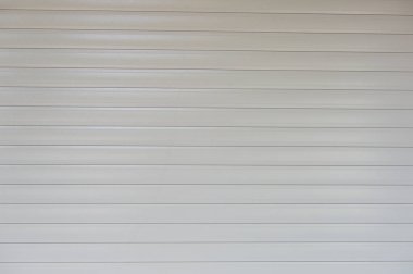 Fabrikada, depoda, garajda ve endüstriyel depoda kullanılan otomatik metal paten kapısının yakın çekimi. Bükülebilir ve katlanabilir metal levha yer tasarrufu sunuyor ve kentsel ve kırsal hissi sağlıyor