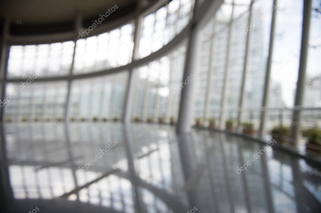 Blur background interior view looking out toward to empty office lobby and entrance doors and glass curtain wall