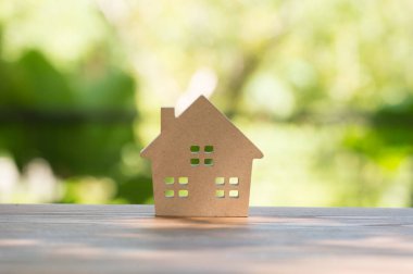 minyatür ev ahşap sahte yukarı gün öğlen ışık üzerinde bulanık yeşil bahçe üzerinde. Emlak Gayrimenkul yatırım kavramı için görüntü.