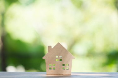 minyatür ev ahşap sahte yukarı gün öğlen ışık üzerinde bulanık yeşil bahçe üzerinde. Emlak Gayrimenkul yatırım kavramı için görüntü.