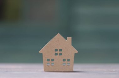 minyatür ev ahşap sahte yukarı gün öğlen ışık üzerinde bulanık yeşil bahçe üzerinde. Emlak Gayrimenkul yatırım kavramı için görüntü.