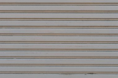 Fabrikada, depoda, garajda ve endüstriyel depoda kullanılan otomatik metal paten kapısının yakın çekimi. Bükülebilir ve katlanabilir metal levha yer tasarrufu sunuyor ve kentsel ve kırsal hissi sağlıyor