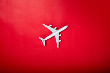Kırmızı arka planda minyatür oyuncak uçak. Uçakla yolculuk..