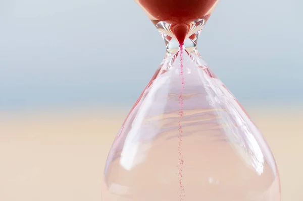 Hourglass with flowing sand on table. Time management