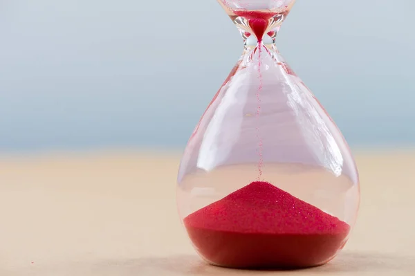 Hourglass with flowing sand on table. Time management