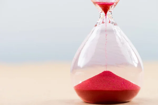 Hourglass with flowing sand on table. Time management