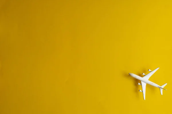 Miniaturní letadýlko na žlutém pozadí. Výlet letadlem. — Stock fotografie