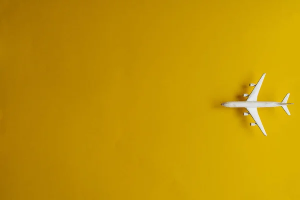 Miniaturní letadýlko na žlutém pozadí. Výlet letadlem. — Stock fotografie