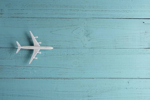 Miniaturní hračka letadlo na dřevěném pozadí. Výlet letadlem. — Stock fotografie