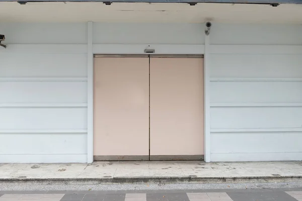 Тротуар через стену и дверь — стоковое фото