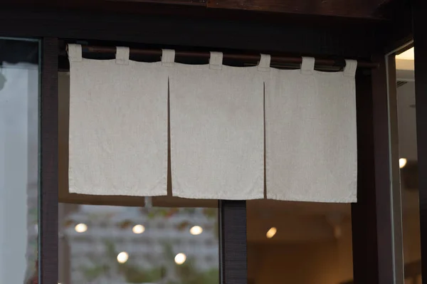 The curtain-like fabric that hangs in front of traditional Japan