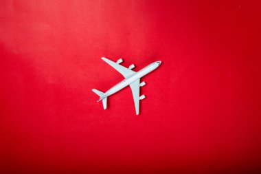 Kırmızı arka planda minyatür oyuncak uçak. Uçakla yolculuk..