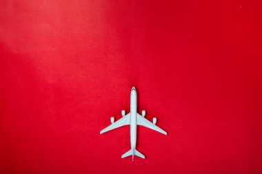 Kırmızı arka planda minyatür oyuncak uçak. Uçakla yolculuk..