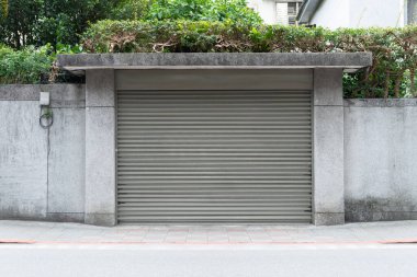 Fabrikada, depoda, garajda ve endüstriyel depoda kullanılan otomatik metal paten kapısının yakın çekimi. Bükülebilir ve katlanabilir metal levha yer tasarrufu sunuyor ve kentsel ve kırsal hissi sağlıyor