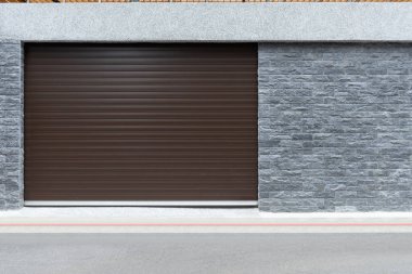 Fabrikada, depoda, garajda ve endüstriyel depoda kullanılan otomatik metal paten kapısının yakın çekimi. Bükülebilir ve katlanabilir metal levha yer tasarrufu sunuyor ve kentsel ve kırsal hissi sağlıyor