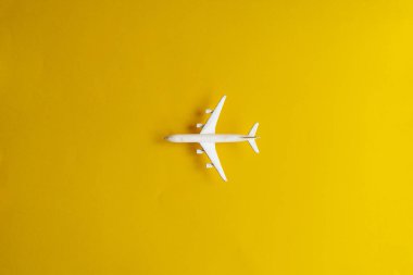 Sarı arka planda minyatür oyuncak uçak. Uçakla yolculuk..