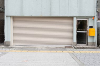 Fabrikada, depoda, garajda ve endüstriyel depoda kullanılan otomatik metal paten kapısının yakın çekimi. Bükülebilir ve katlanabilir metal levha yer tasarrufu sunuyor ve kentsel ve kırsal hissi sağlıyor