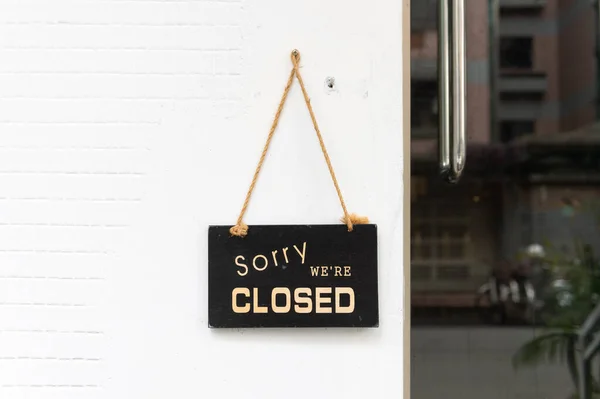 sorry we are closed sign hanging outside a restaurant, store, office or other