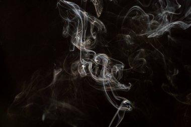 Siyah arkaplanda beyaz dumanı yakma hareketinin soyut güzel bir parçası.