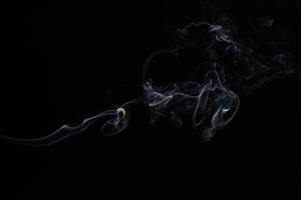 Abstract beautiful fragment movement of burn white smoke on black background.