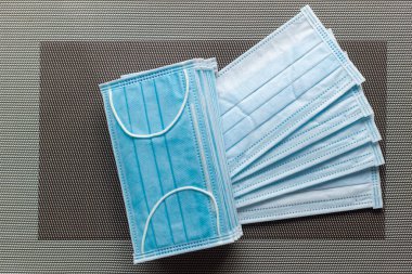 Ahşap masa arkasında tıbbi yüz maskesi, tahta arka planda yeşil yüz maskesi seçici odak.