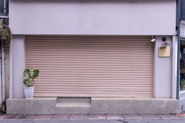 Fabrikada, depoda, garajda ve endüstriyel depoda kullanılan otomatik metal paten kapısının yakın çekimi. Bükülebilir ve katlanabilir metal levha yer tasarrufu sunuyor ve kentsel ve kırsal hissi sağlıyor