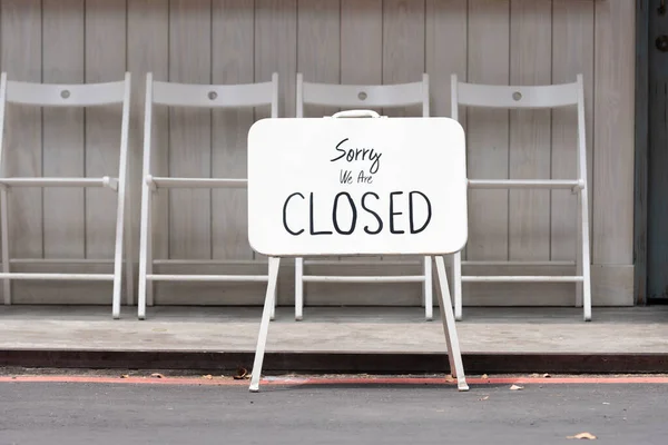 sorry we are closed sign hanging outside a restaurant, store, office or other