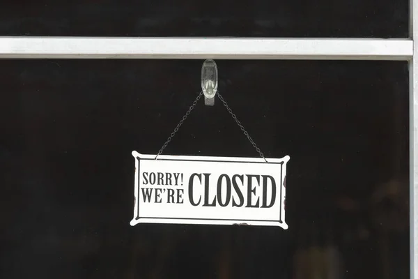 sorry we are closed sign hanging outside a restaurant, store, office or other