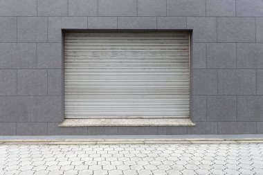 Fabrikada, depoda, garajda ve endüstriyel depoda kullanılan otomatik metal paten kapısının yakın çekimi. Bükülebilir ve katlanabilir metal levha yer tasarrufu sunuyor ve kentsel ve kırsal hissi sağlıyor