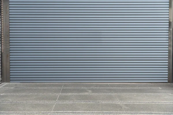 A closeup shot of automatic metal roller door used in factory, storage, garage, and industrial warehouse. The corrugated and foldable metal sheet offer space saving and provide urban and rustic feel