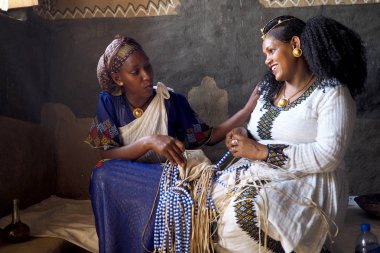 Alitena, Etiyopya - 2 Haziran 2019 : İki kadın geleneksel Etiyopya düğün dekorasyonu boncuk üzerinde çalışıyor.