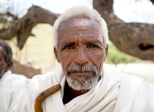 Alitena, Etiópia-1 június 2019: öreg ember a vidéki Etiópiában, öltözött hagyományos fehér lovagolt, fa sétapálca — Stock Fotó