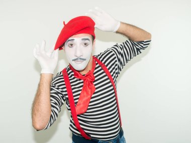 mutlu erkek MIME. Beyaz arka plan üzerinde izole, çizgili gömlek ve kırmızı şapka giymiş.