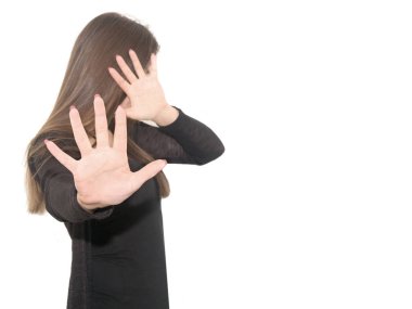 a young woman in black clothes pulled her hands and hid  face. The girl feels fear. Isolated on a white background. clipart