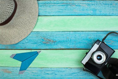 Eski fotoğraf makinesi ve kağıt tesisi ahşap arka plan üzerinde ile şapka. Üstten görünüm 