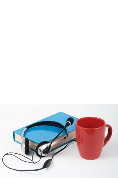 Kopfhörer Über Blauem Gebundenem Buch Mit Tasse Auf Weißem Hintergrund — Stockfoto