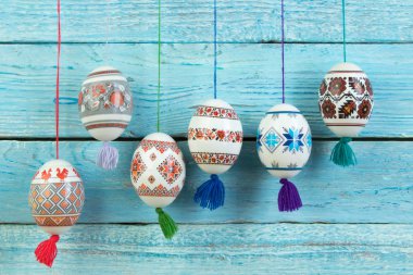 Mutlu paskalya kartı şablonu üzerinde ahşap arka plan asılı renkli parlak Paskalya yumurtaları ile