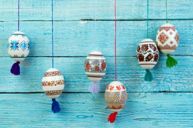 Mutlu paskalya kartı şablonu üzerinde ahşap arka plan asılı renkli parlak Paskalya yumurtaları ile