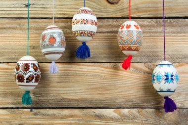 Mutlu paskalya kartı şablonu üzerinde ahşap arka plan asılı renkli parlak Paskalya yumurtaları ile