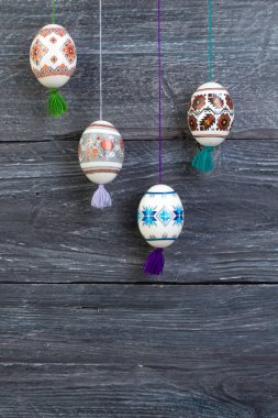 Mutlu paskalya kartı şablonu üzerinde ahşap arka plan asılı renkli parlak Paskalya yumurtaları ile