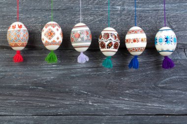 Mutlu paskalya kartı şablonu üzerinde ahşap arka plan asılı renkli parlak Paskalya yumurtaları ile