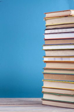 Mavi arka plan, kısmi görünümü üzerinde renkli gerçek kitap yığını. Okula dönüş. Uzay kopyalayın. Eğitim arka plan