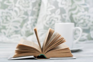 Açık ciltli kitap, ahşap masa bardakta. Doğal arka plan. Okula dönüş. Metin için yer kopyalayın