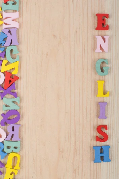 Englisches Wort Auf Hölzernem Hintergrund Bestehend Aus Bunten Abc Buchstaben — Stockfoto