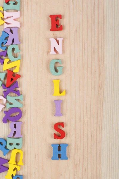 Englisches Wort Auf Hölzernem Hintergrund Bestehend Aus Bunten Abc Buchstaben — Stockfoto