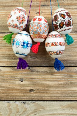 Mutlu paskalya kartı. Ahşap masa arka plan üzerinde renkli parlak Paskalya yumurtaları. Metin için yer kopyalayın