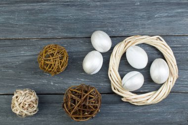 Mutlu Paskalyalar. Tahta arka planda yumurtalar... Toplar, sarmaşıklardan örülmüş çelenkler. Uzayı metin için kopyala. Üst görünüm