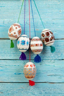 Mutlu paskalya kartı. Mavi ahşap masa arka plan üzerinde renkli parlak Paskalya yumurtaları. Metin için yer kopyalayın